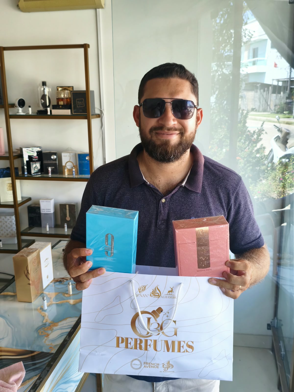 Cliente com perfumes e sacola da J3G